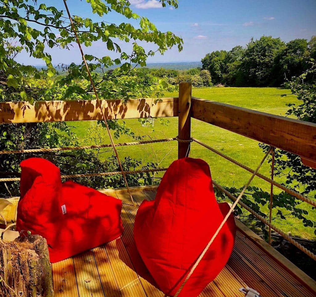 Red bean bags on a Treehouse Deck Platform looking across Surrey countryside