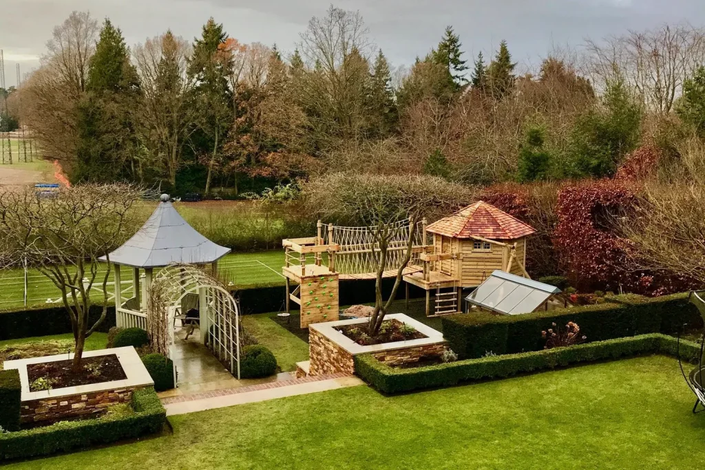 Treehouse play area set into a formal garden space with Deck Platform leading to an 'Island' Deck with a Climbing Wall.