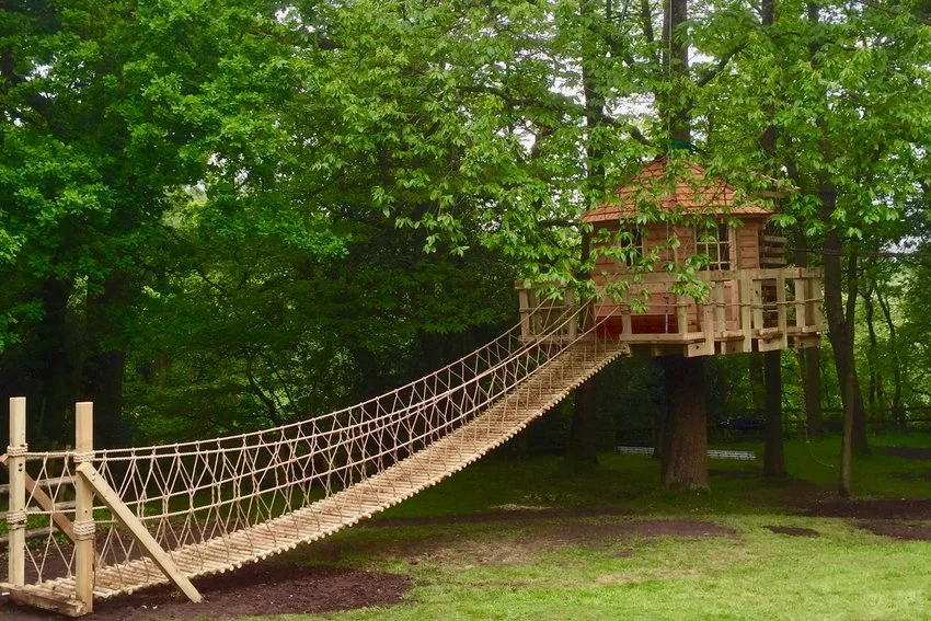 https://d9a3h2d6.rocketcdn.me/wp-content/uploads/2022/10/Log-Rope-Bridge-by-Treehouse-Life-Ltd-leading-into-magical-suspended-floating-treehouse.webp