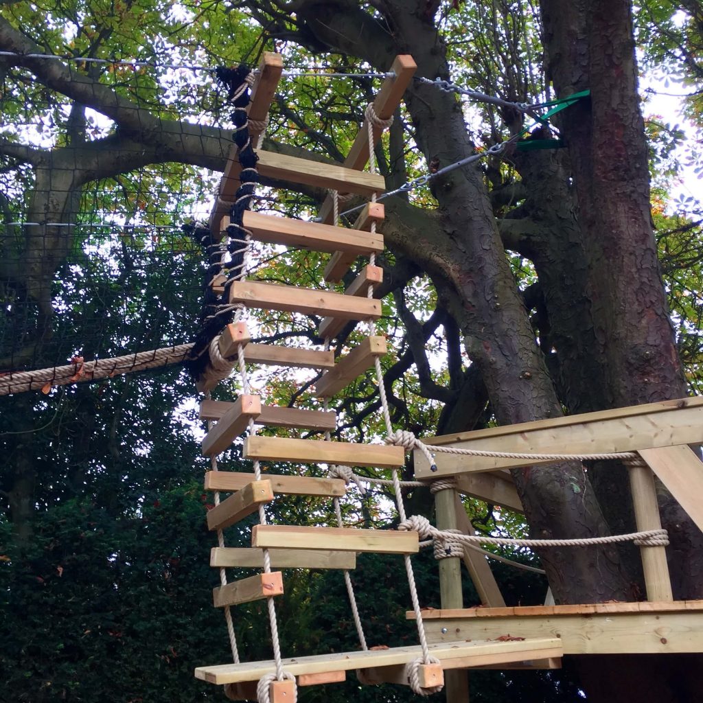 Big tree suspended 4-sided Rope Ladder leading from Tree Deck and into a higher Treetop Walkway netted Rope Bridge.