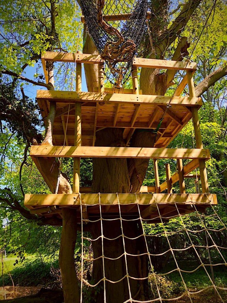 A two-platform family woodland play deck, with cargo climbing net.