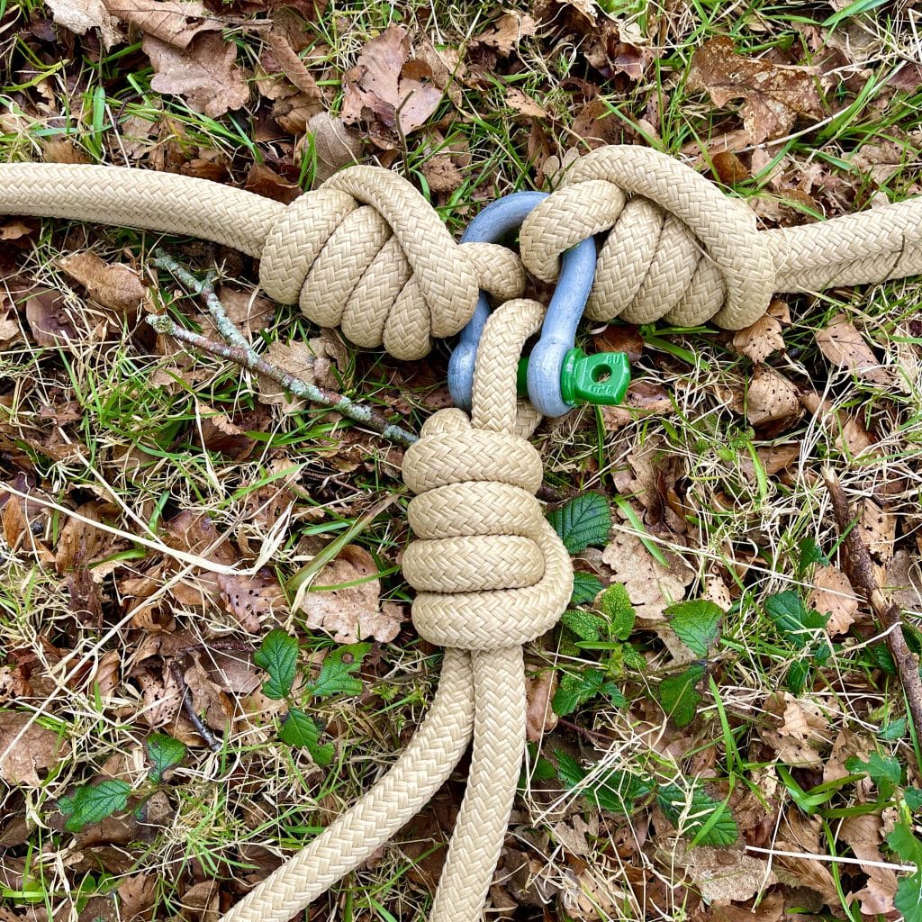 3 rope knots on the ground of brown leaves and grass. The rope knots form part of a nest swing at Muncaster Castle.