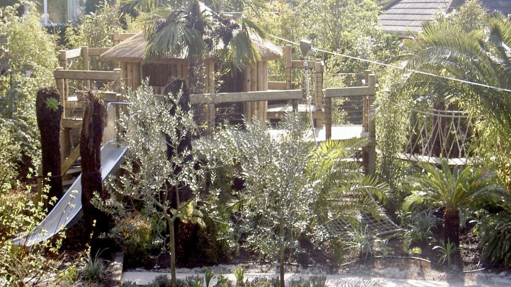 A large landscaped treehouse in a garden in Windsor, surrounded by tropical shrubbery.